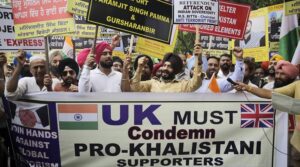 [Image of a group of people holding placards and shouting slogans outside the Indian High Commission in London]